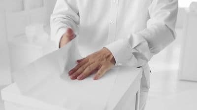 a man in a white shirt is holding a piece of paper