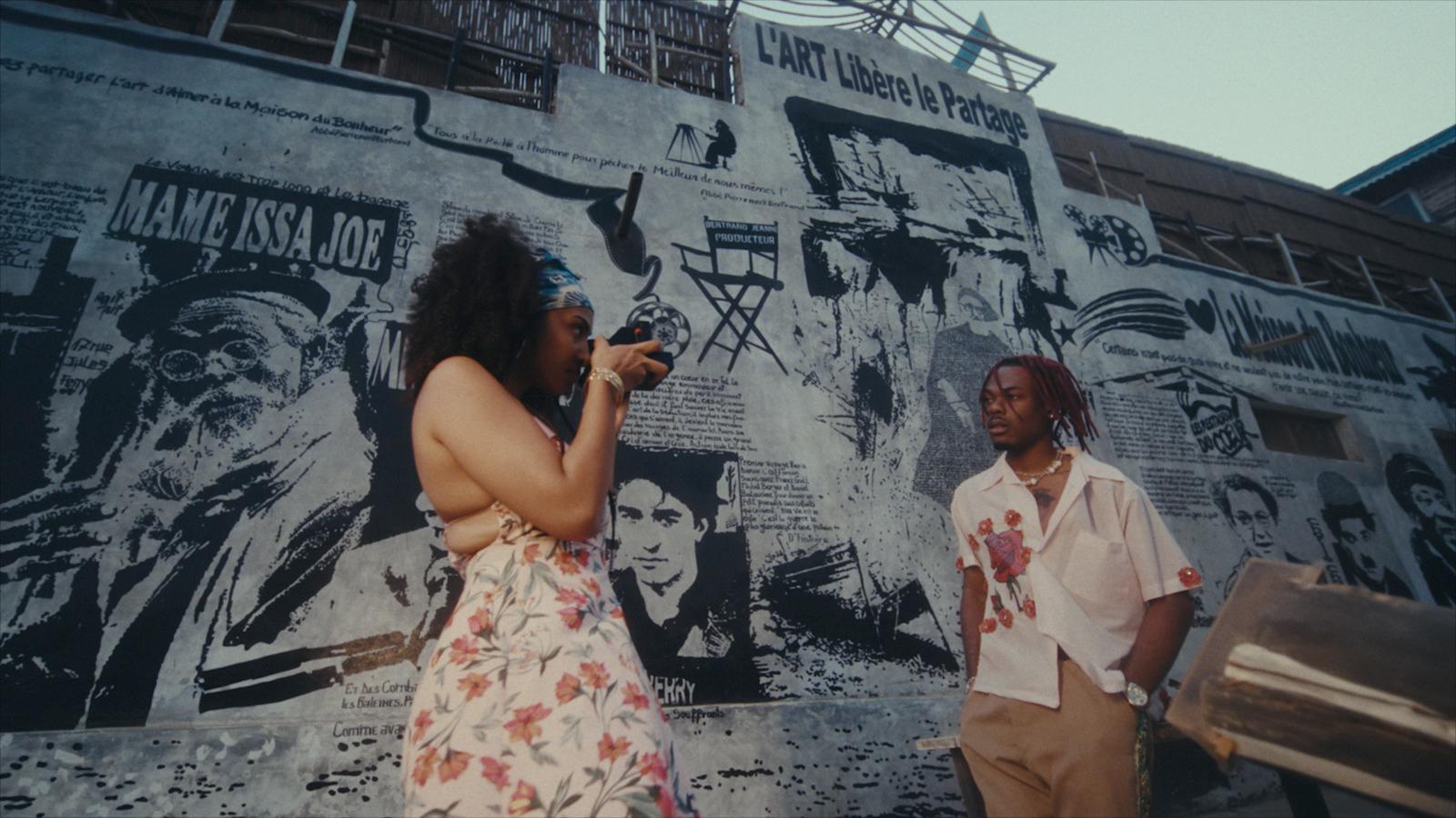 a woman standing next to a man on a cell phone