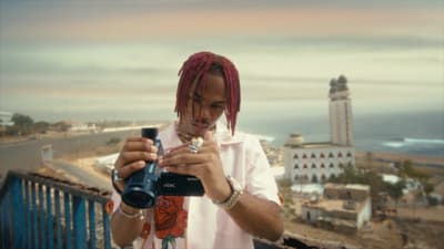 a man with dreadlocks taking a picture with a camera