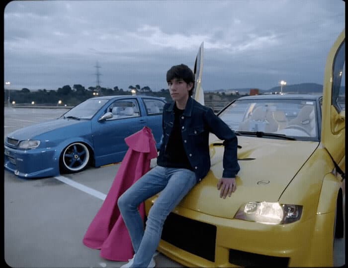 a man sitting on the hood of a yellow car