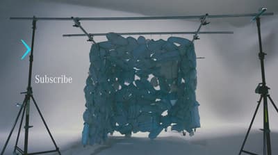 a picture of a blue piece of cloth hanging on a tripod