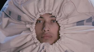 a woman is hiding under a white blanket