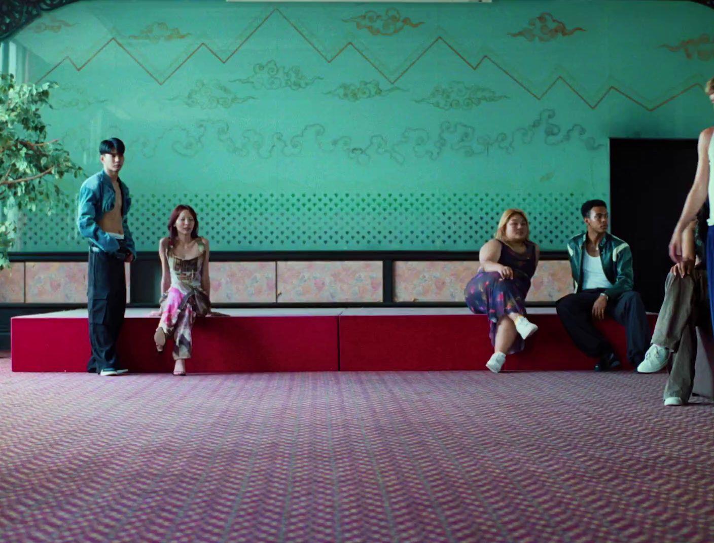 a group of people sitting on top of a red bench