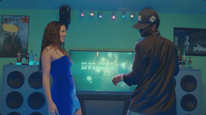 a man and a woman standing in front of a tv