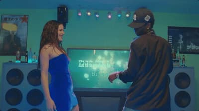 a man and a woman standing in front of a tv