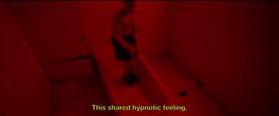 a person standing on a step in a red lit room
