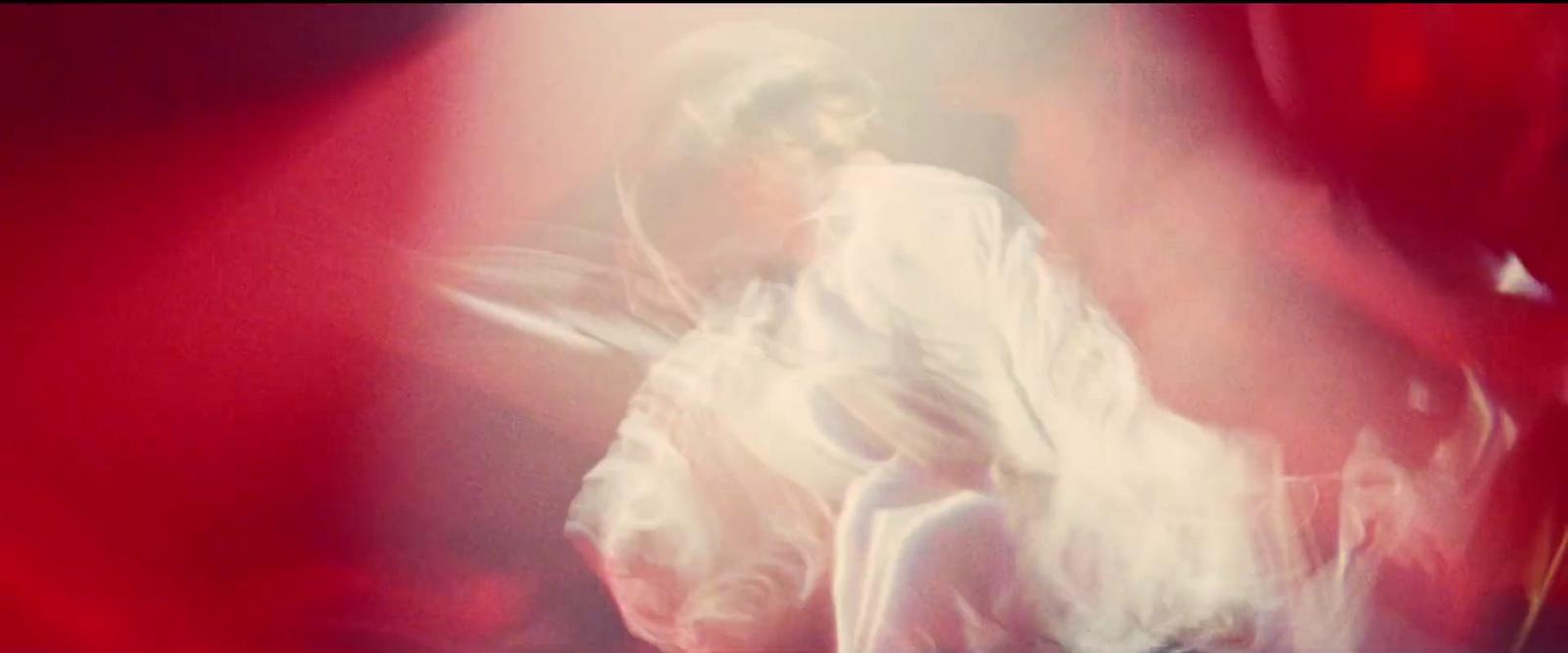 a blurry photo of a man in a white suit