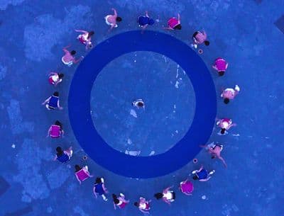a group of people standing around a blue circle