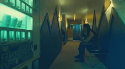 a person sitting on a bench in a hallway