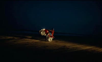 a tractor in the dark on a dirt road