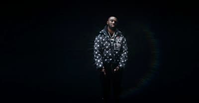 a man standing in the dark with his hands in his pockets