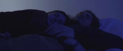 a couple of women laying next to each other on a bed