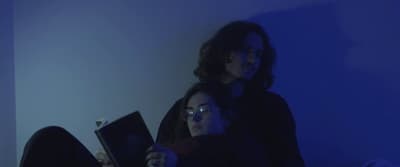 a couple of people sitting on a bed