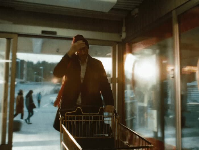 a man pushing a shopping cart down a street