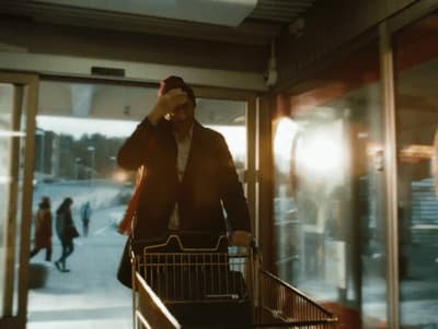 a man pushing a shopping cart down a street