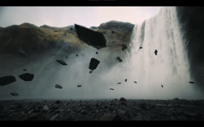 a group of birds flying over a waterfall