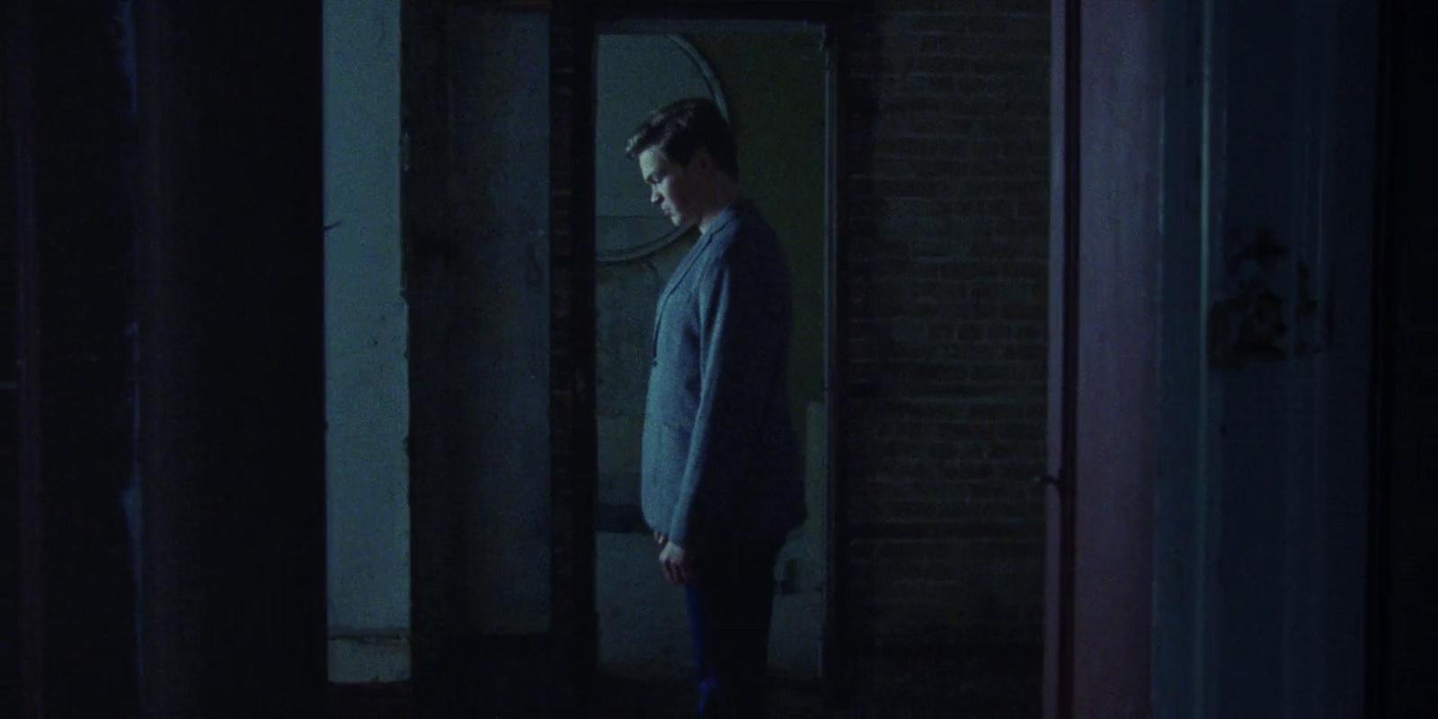 a man standing in a doorway at night