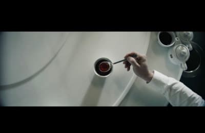 a person holding a spoon in front of a white wall