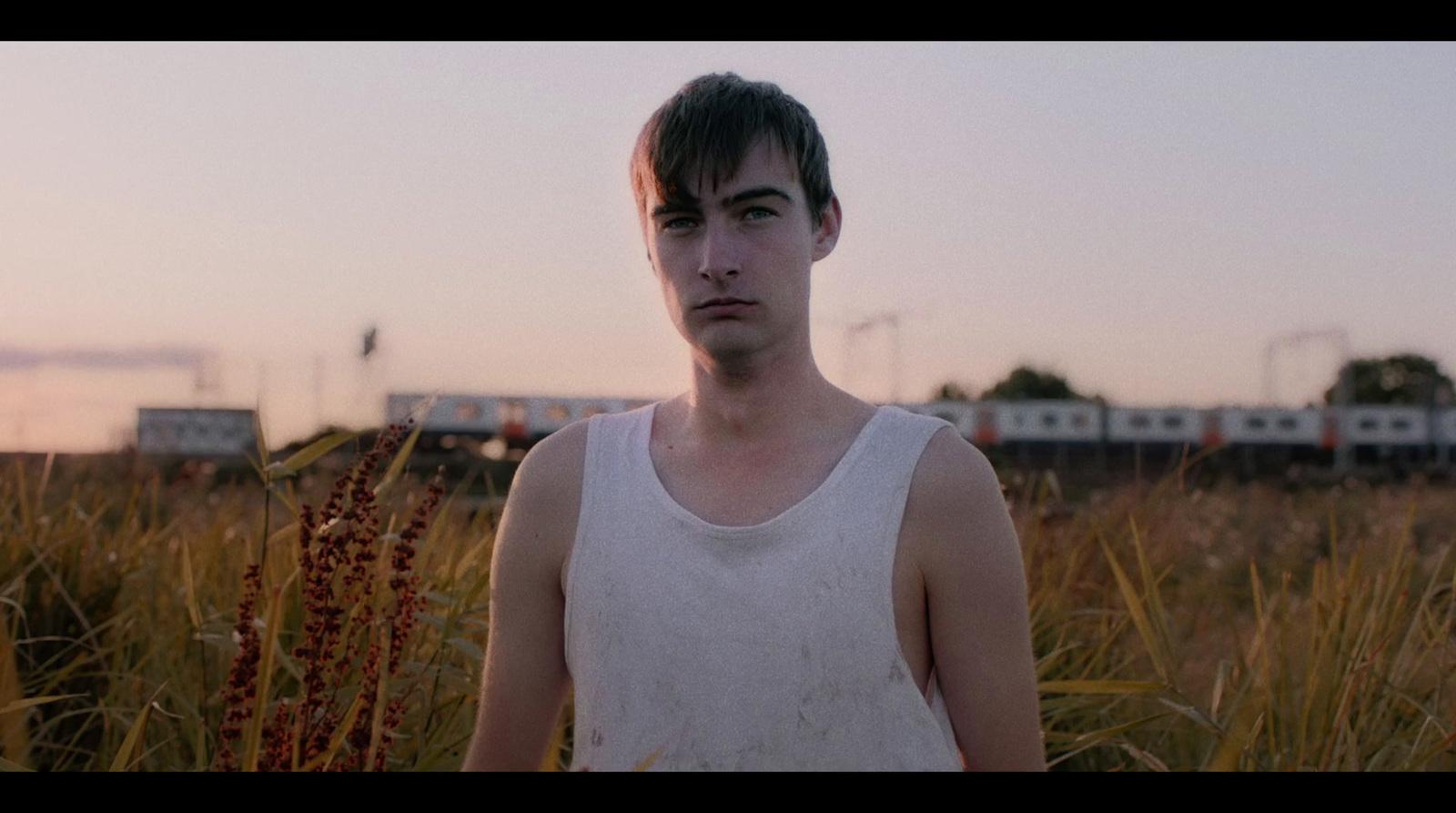 a man standing in a field of tall grass