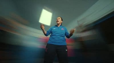 a woman in a blue shirt is holding her hands out