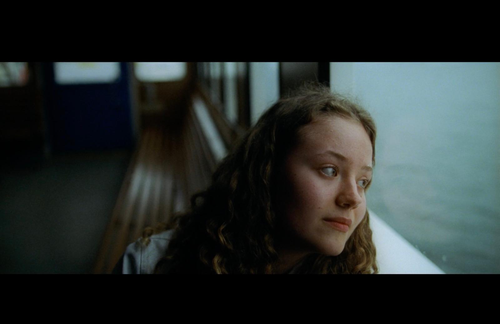 a girl looking out a window at something