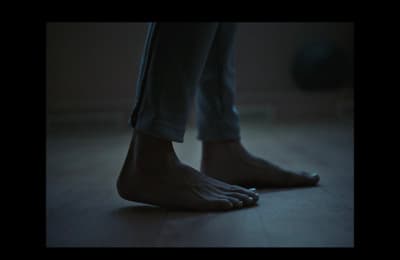 a person standing on a wooden floor with their bare feet