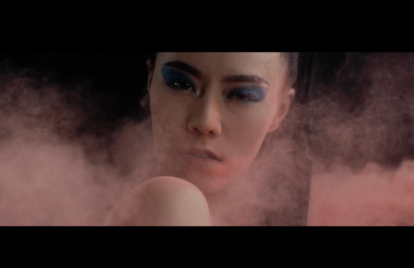 a woman with blue eyes and smoke behind her