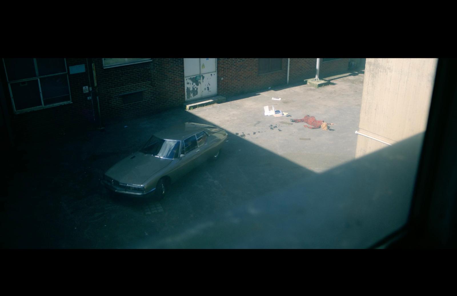 a car parked in a parking lot next to a building