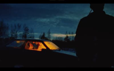 a man standing next to a car in the snow
