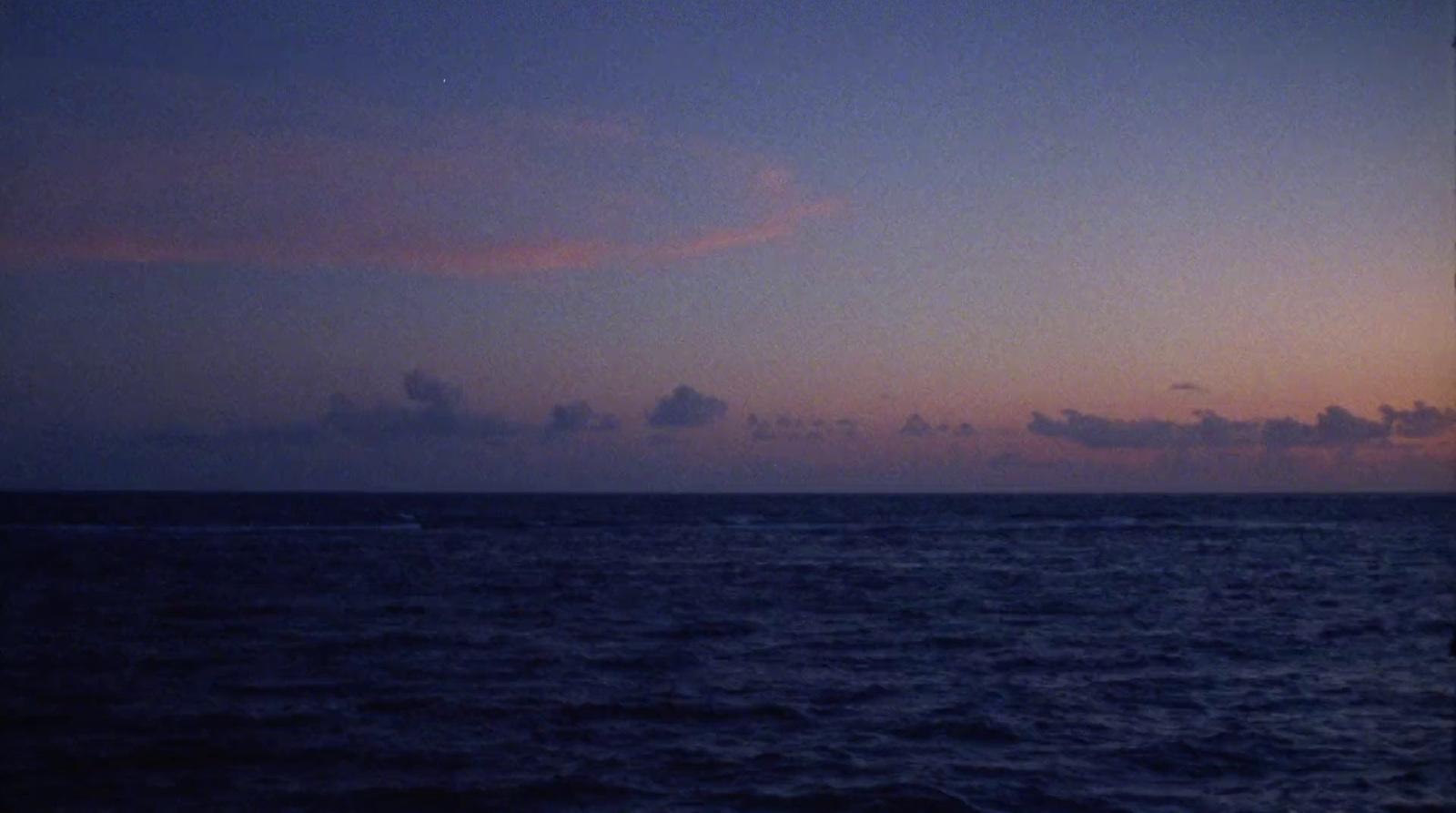 a view of the ocean at dusk from a boat