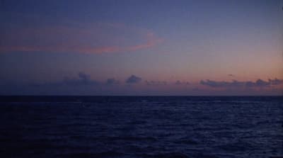 a view of the ocean at dusk from a boat