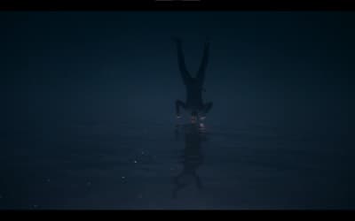 a person standing in the water in the dark