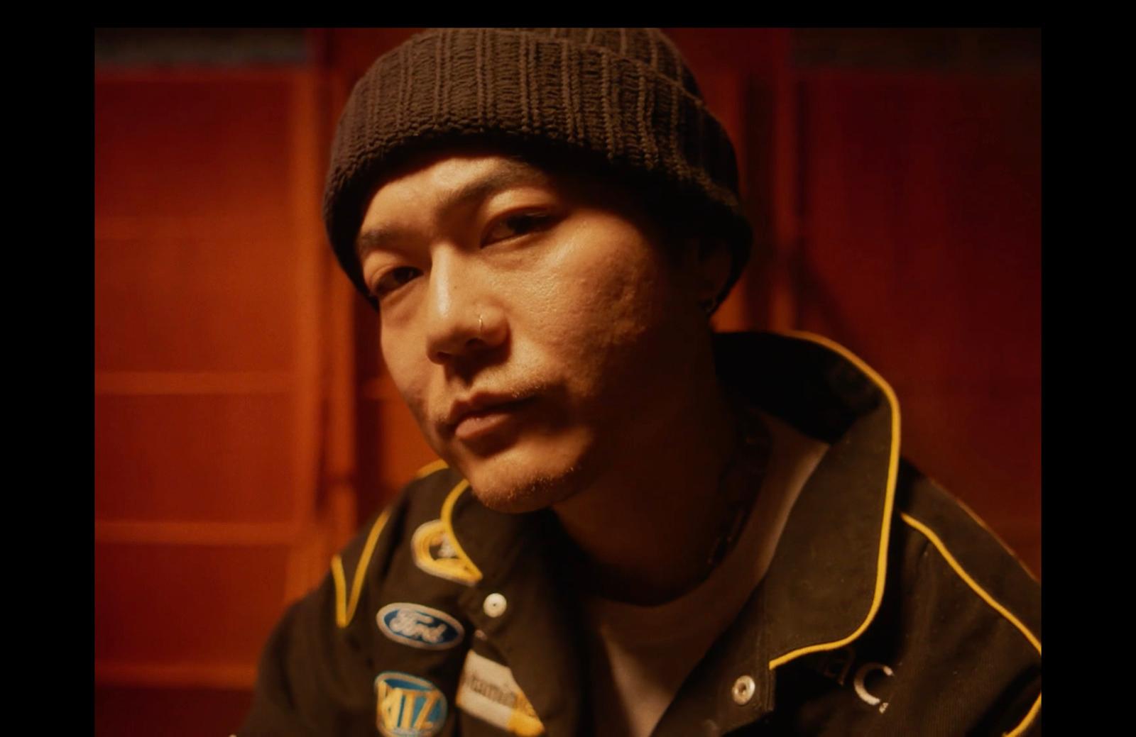 a man wearing a hat and jacket in a room