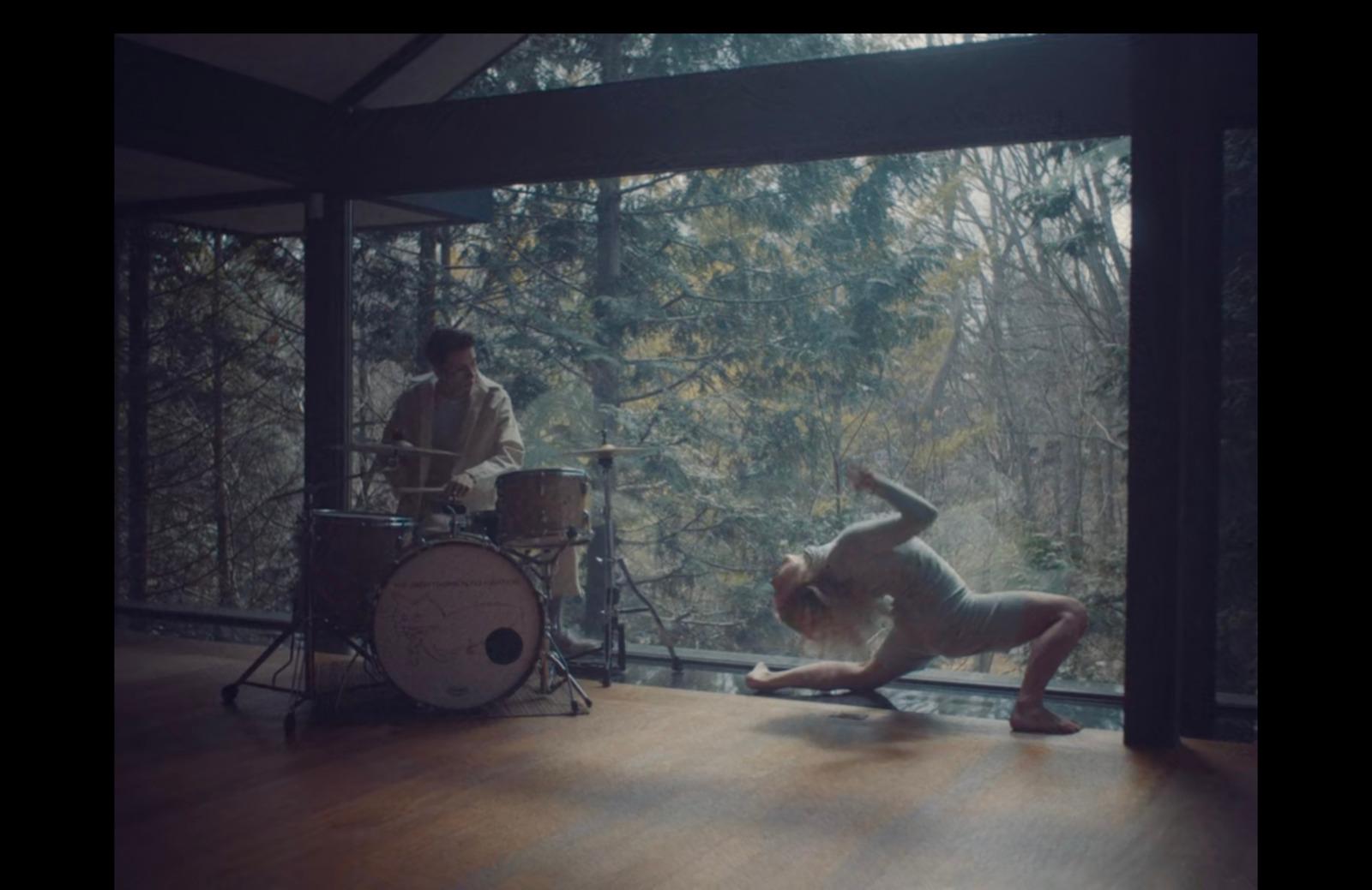 a man is doing a handstand in front of a drum set