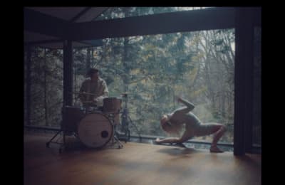 a man is doing a handstand in front of a drum set