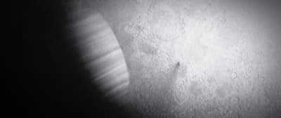 a black and white photo of a light shining on a wall