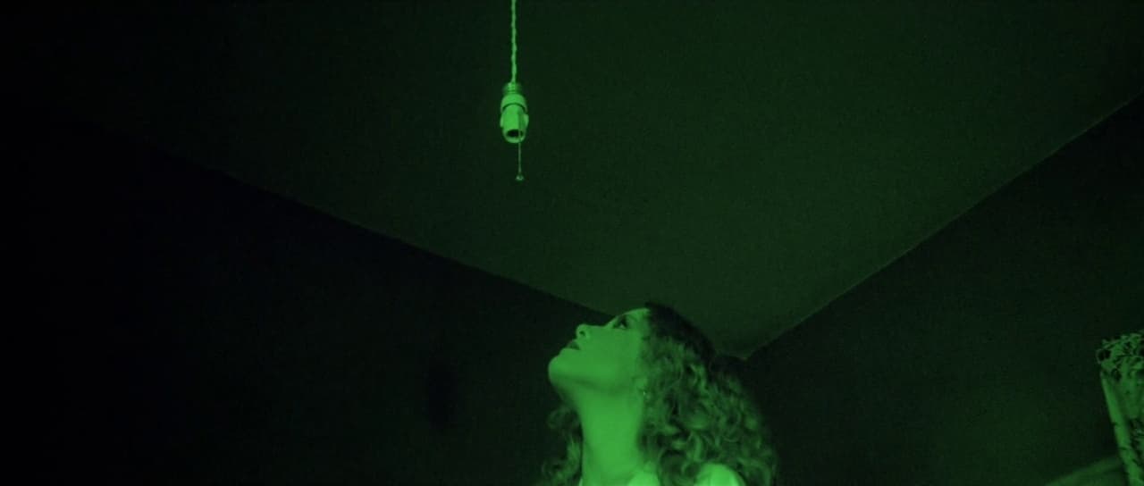 a woman standing in a dark room with her eyes closed