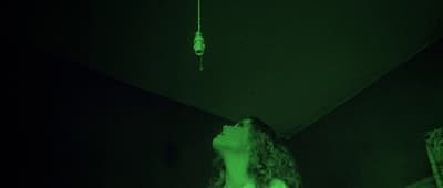a woman standing in a dark room with her eyes closed