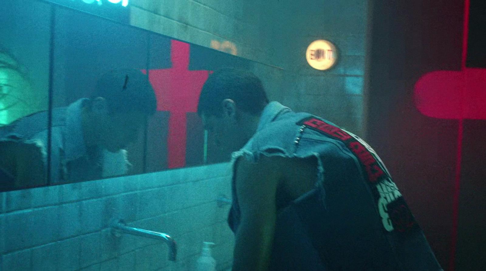 a man standing in front of a bathroom mirror