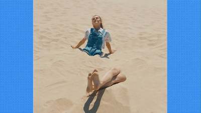 a woman laying on top of a sandy beach