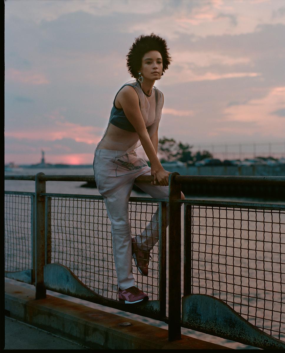 a woman leaning on a rail next to a body of water