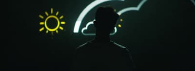 a man standing in front of a neon sign