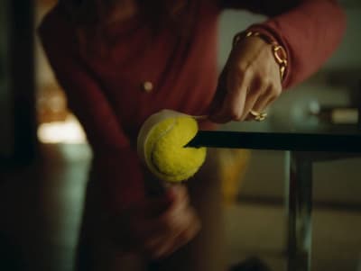 a person holding a tennis ball on a racket