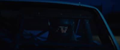 a man sitting in the back of a car in the dark