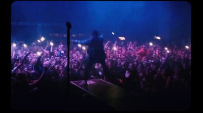 a man standing on top of a stage in front of a crowd
