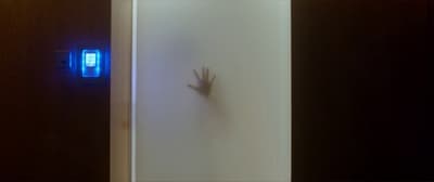 a hand is coming out of a door