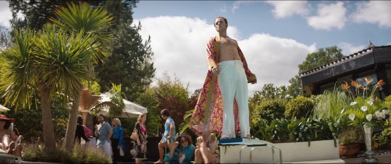 a man standing on top of a statue in a garden
