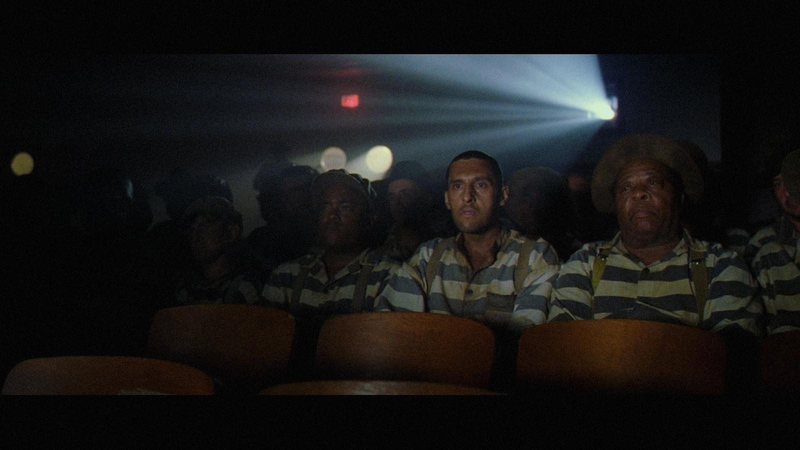 a group of men sitting next to each other in front of a crowd