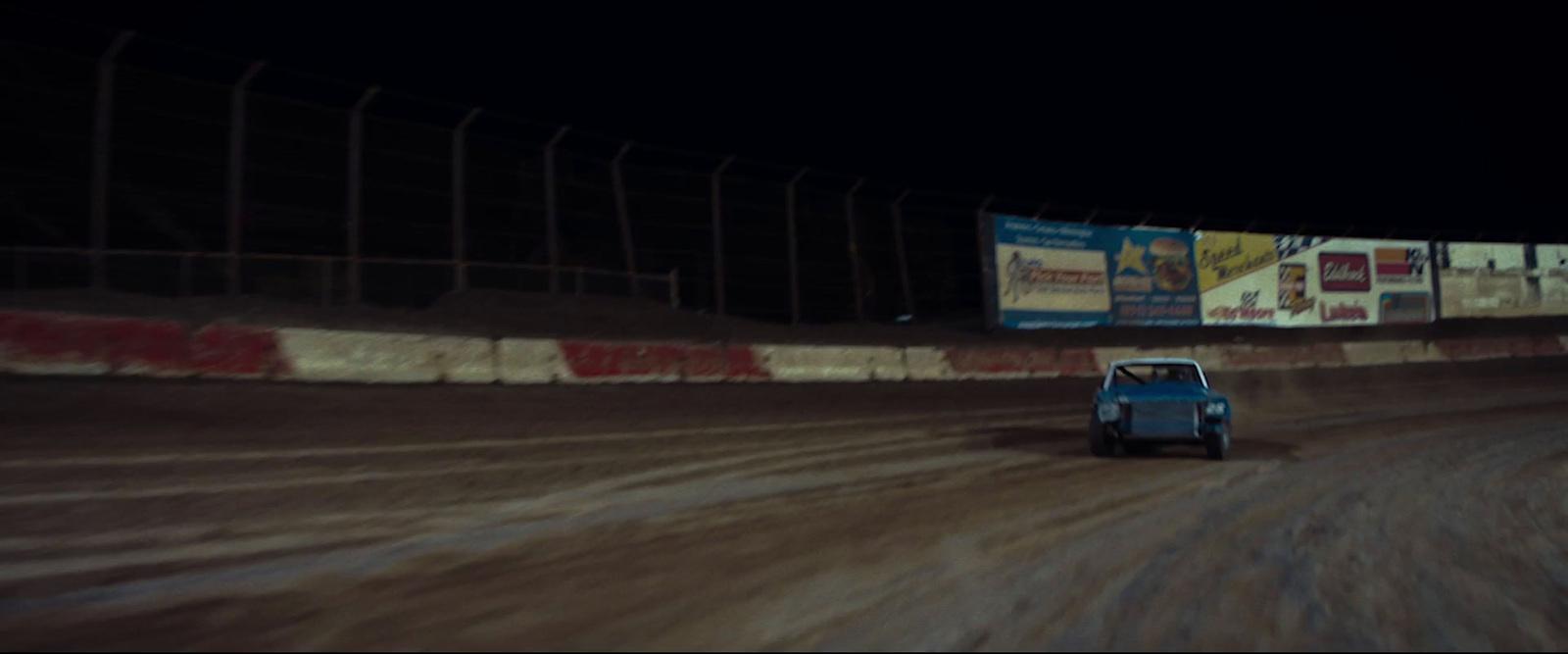 a car driving down a dirt road at night