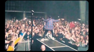 a man standing on top of a stage in front of a crowd